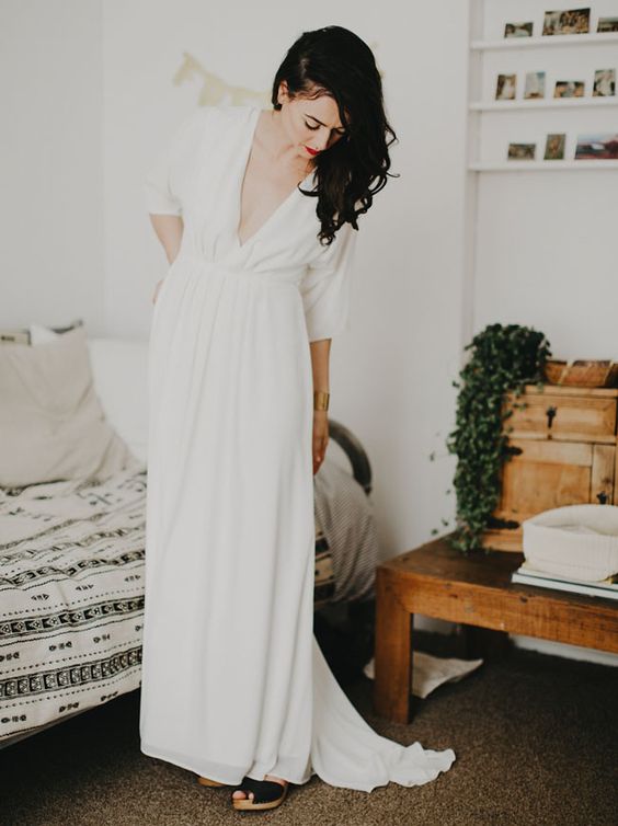 a casual A line wedding dress with a depe neckline, short sleeves and a draped bodice and skirt is a lovely idea for a modern bride