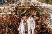 21 a super lush and pretty modern fall wedding ceremony space done with lots of colorful leaves and greenery is wow