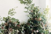 21 an overgrown flower wedding altar of greenery, colorful foliage, blush blooms looks like a piece of a real garden for a ceremony