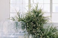25 a lovely modern wedding ceremony space with lots of greenery and white blooms forming a wedding altar looks amazingly inspiring