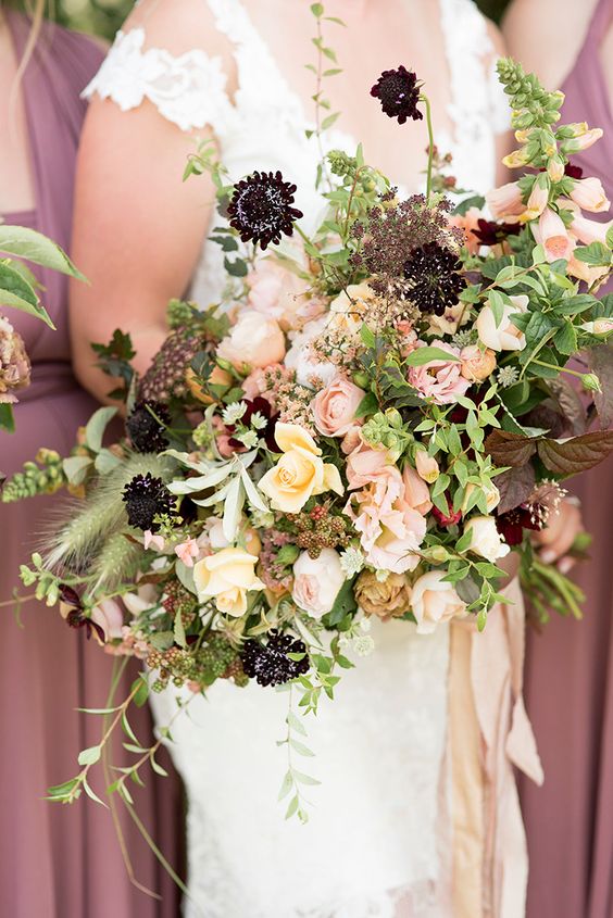 a gorgeous fall wedding bouquet of peachy, blush and deep purple blooms and lots of greenery and ribbons is a cool idea