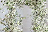 26 a jaw-dropping white blooming branches wedding arch is a gorgeous and absolutely amazing idea for a spring wedding