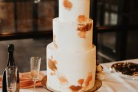 31 a chic modern fall wedding cake in white, with rust brushstrokes, a rust and a white rose and greenery on top is a very chic idea