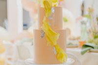 32 a modern bridal shower cake in pastel orange, with yellow sugar petals and silver leaf is an out of the box idea