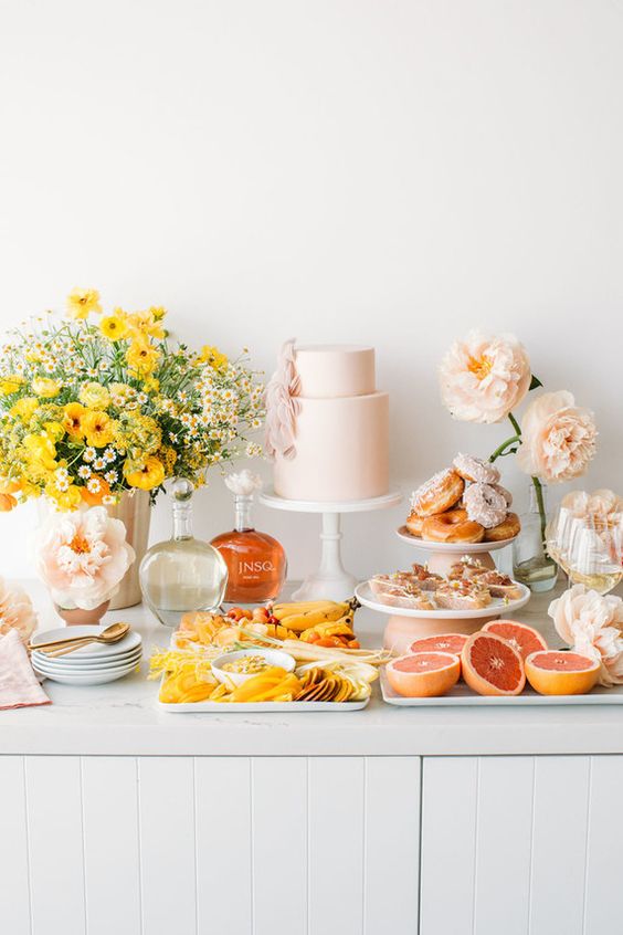 a modern pastel bridal shower dessert table with bold blooms and pastel ones, with desserts, appetizers and a pastel pink wedding cake