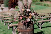 35 fall rustic and boho wedding floral arrangement with rust, blush and deep purple blooms and foliage, pampas grass on a barrel