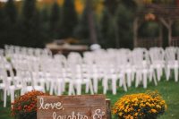37 rustic fall wedding decor with a sign, pumpkins, bright potted blooms is a lovely idea for a rustic fall wedding ceremony space