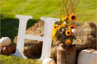 40 hay with pumpkins, bold blooms, twigs and branches plus a monogram is a very cool and easy to realize idea for a fall wedding