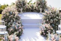 a beautiful pastel wedding ceremony space is amazing with pink, blue and white blooms and greenery is gorgeous