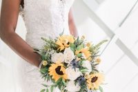 a chic cascading wedding bouquet of white roses, sunflowers, billy balls, greenery and thistles is a lovely idea for a summer bride