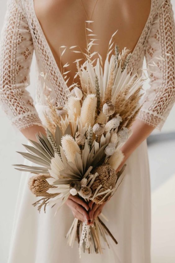 a chic dried flower wedding bouquet with fronds, bunny tails, proteas, grasses and seed pods and wheat is a lovely idea for a summer or fall boho bride