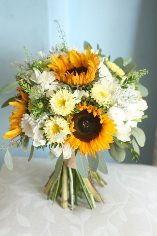 a colorful and chic wedding bouquet of sunflowers, white and yellow blooms and greenery is a lovely idea for a summer bride