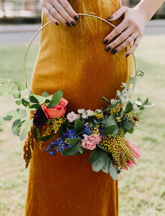 a colorful hoop wedding bouquet with blue, pink, yellow flowers and lush greenery is a beautiful idea for a bright summer wedding