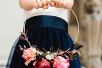 a colorful hoop wedding bouquet with greenery, pink and red blooms and long burgundy ribbons is a very cool and bold idea