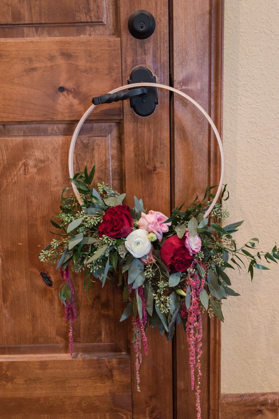 a colorful hoop wedding bouquet with lush eucalyptus, pink, deep red and white blooms and lisianthus is a bold solution for summer or dall