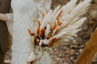 a cool fall wedding bouquet of dried bunny tails, pampas grass, blooms and grasses, neutral or spray painted for a fall boho bride