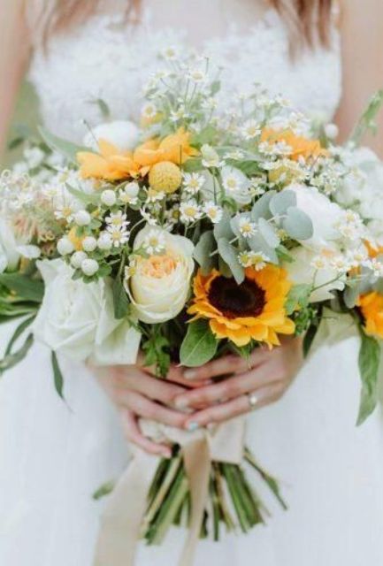 a delicate wedding bouquet of peachy and white blooms, sunflowers, berries, daisies, greenery is a lovely idea for spring