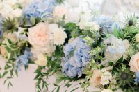 a delicate wedding centerpiece of pink, white and blue flowers and greenery, thistles and other beautiful stuff is a great idea