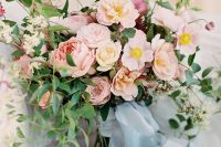 a fab wedding bouquet of pink roses and peonies, white and dusty pink blooms, greenery and blue ribbons is wow