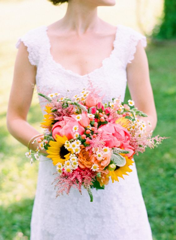 a fun and colorful summer wedding bouquet of pink peonies, daisies, sunflowers, some fillers like astilbe is a lovely idea for summer