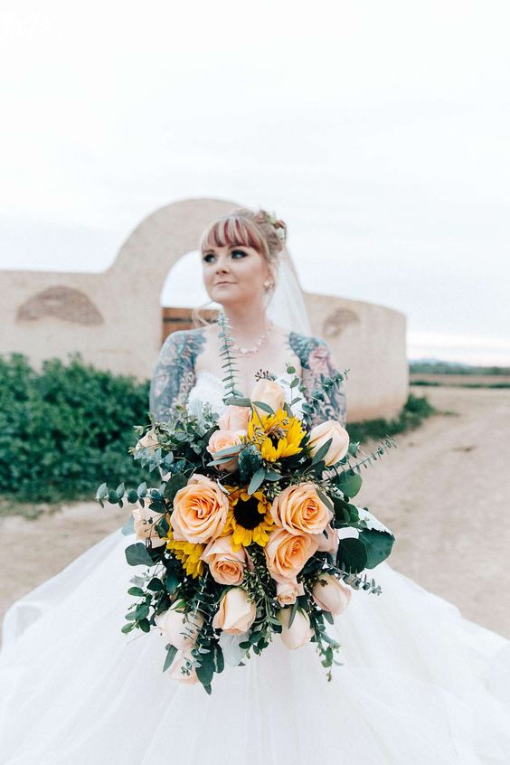 a gorgeous modern wedding bouquet of large peachy roses, sunflowers and eucalyptus is an amazing idea for a summer bride