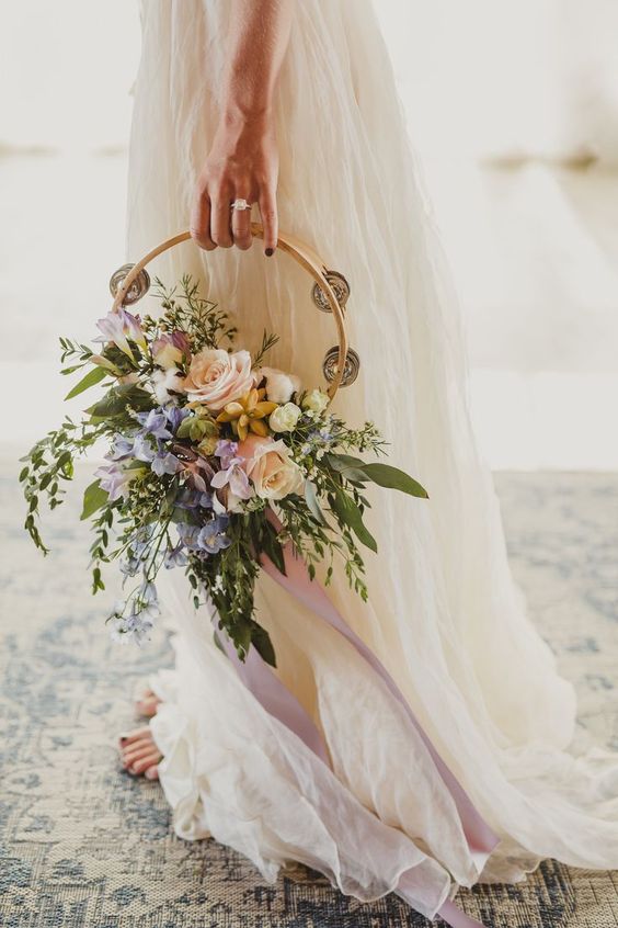 a hoop wedding bouquet with lush greenery and pastel blooms with plenty of texture and dimension is a lovely idea