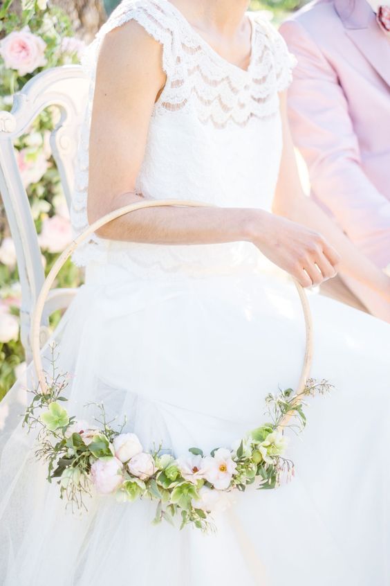 a large hoop wedding bouquet with some greenery and delicate pink blooms is a lovely idea for a spring or summer wedding