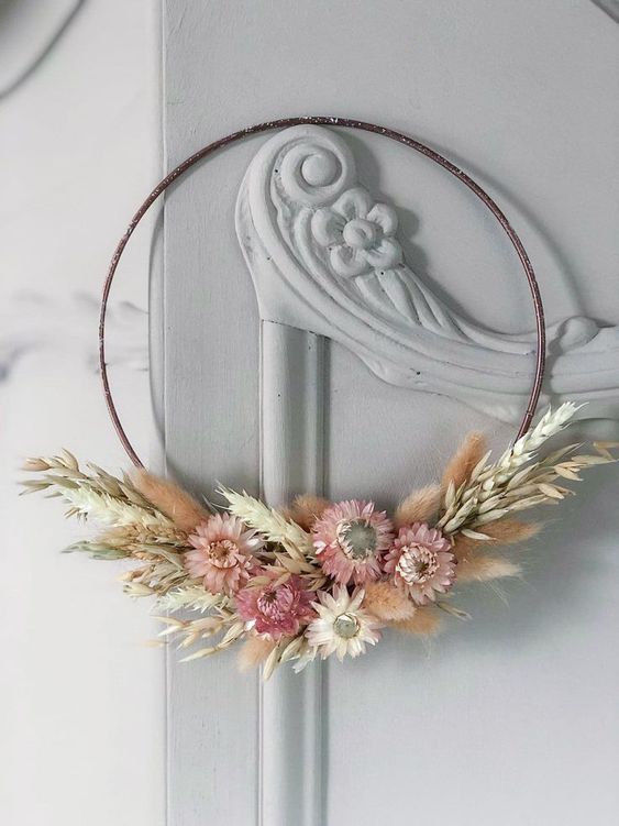 a lovely hoop dried flower wreath with wheat and pink blooms looks very delicate and chic, and will match rustic or boho style