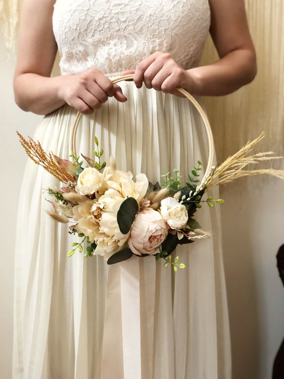 a neutral hoop wedding bouquet with neutral and pastel blooms, greenery and wheat is a lovely and delicate idea for a bride or bridesmaid