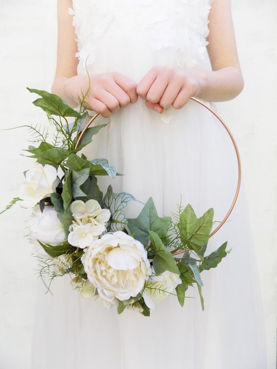 a pretty hoop wedding bouquet with lush white blooms and leaves is a chic idea for a spring wedding, and silk flowers won't wither