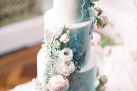 a refined wedding cake in light blue, with blush roses, daisies, blue sugar patterns and greenery is a gorgeous idea to rock