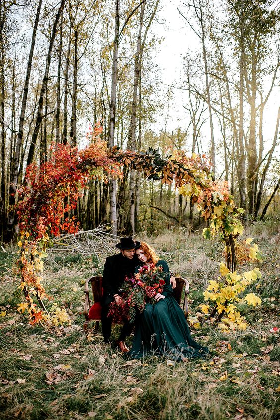 a round boho fall wedding arch decorated with only yellow, rust-colored and burgundy blooms and nothing else is a gorgeous idea