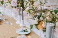 a sophisticated secret garden wedding tablescape with neutral and pastel linens, pastel blooms and greenery, grey candles