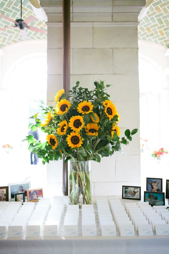 a very easy and gorgeous rustic wedding centerpiece of sunflowers and greenery is a fantastic idea for a rustic wedding