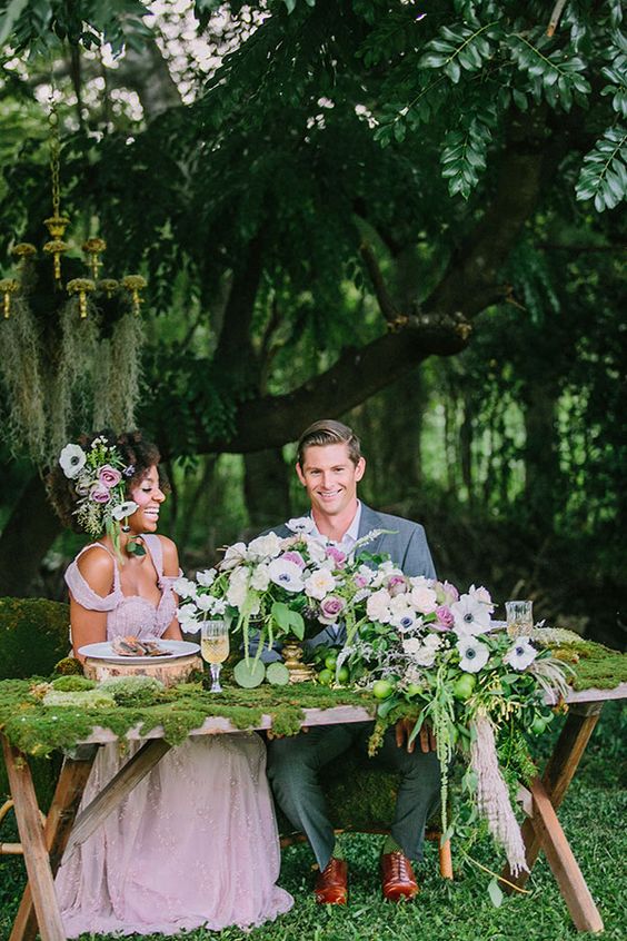 a whimsy secret garden wedding tablescape with a moss tablecloth, white and pink blooms and greenery and gold touches is wow