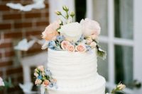 a cute white wedding cake with pastel flowers