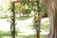 an elegant rustic fall wedding arch with eucalyptus, peachy, white and yellow roses and moss at the base is a cool and stylish solution