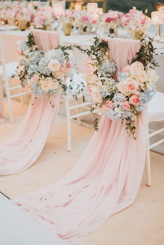 lovely wedding chair decor with pink covers and white, blue and pink blooms and greenery is gorgeous and very chic