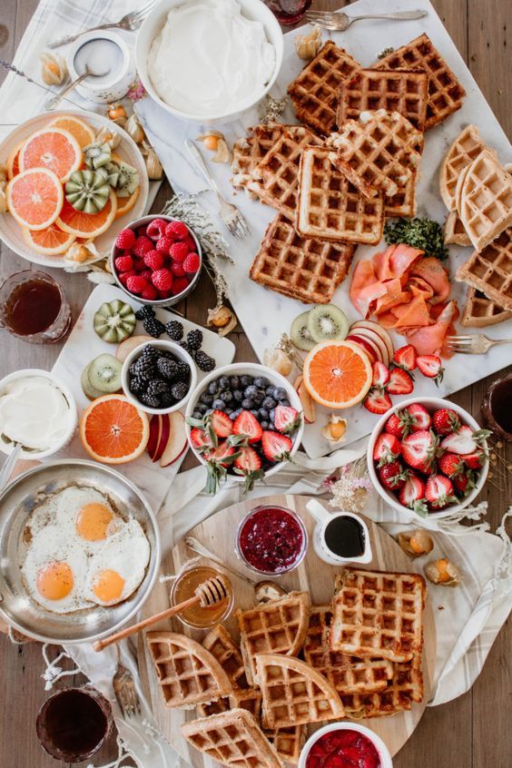 a lovely savory waffle bar with berries, fruits, fried eggs, sauces and lots of waffles is a fab idea for a wedding brunch