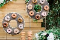 24 mini donuts of plywood on stands as donut displays and donuts on holders for a modern wedding or bridal shower