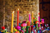 a bold Moroccan bridal shower tablescape with an electric blue table runner and jewel tone vases and candles, colorful napkins is jaw-dropping