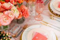 a bold bridal shower tablescape with pink and orange blooms, pink glasses, pink menus and a printed tablecloth, gold cutlery is cool