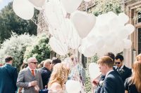 a bunch of white heart-shaped balloons instead of a traditional wedding bouquet is a very fun and bold idea to rock