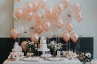 a chic and cool wedding dessert table with peachy and clear balloons, with pink and white florals and gold letter balloons is all cool