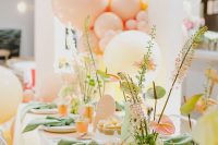 a colorful bridal shower table setting done in orange, yellow, green, pink, with lots of blooms and greenery and colorful napkins is very pretty