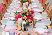 a colorful tropical bridal shower with bold blooms, citrus, candles, colored glasses and pink napkins is a lovely and fun idea
