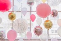 a colorful wedding lounge styled with lots of pink, gold, silver, clear and hot pink balloons is an amazing solution for a modern wedding