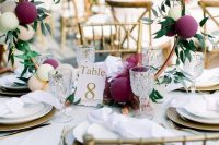 a creative and playful wedding centerpiece of a copper hoop with purple and blush balloons and greenery is a very fresh idea