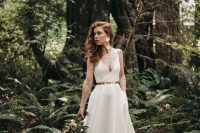 a gorgeous plain A-line wedding dress with a depe neckline, a shiny metallic belt and a pleated skirt with a long trian plus floral earrings