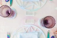 a lovely modern iridescent wedding tablescape with catchy chargers, blue napkins, holographic cutlery, purple glasses is wow
